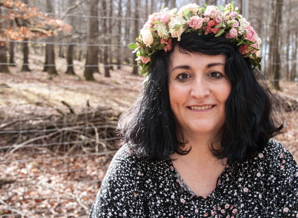 Frau mit Blumenkranz auf dem Kopf im Wald