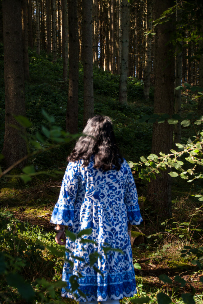 Frau in einem Kleid von hinten in einem Wald